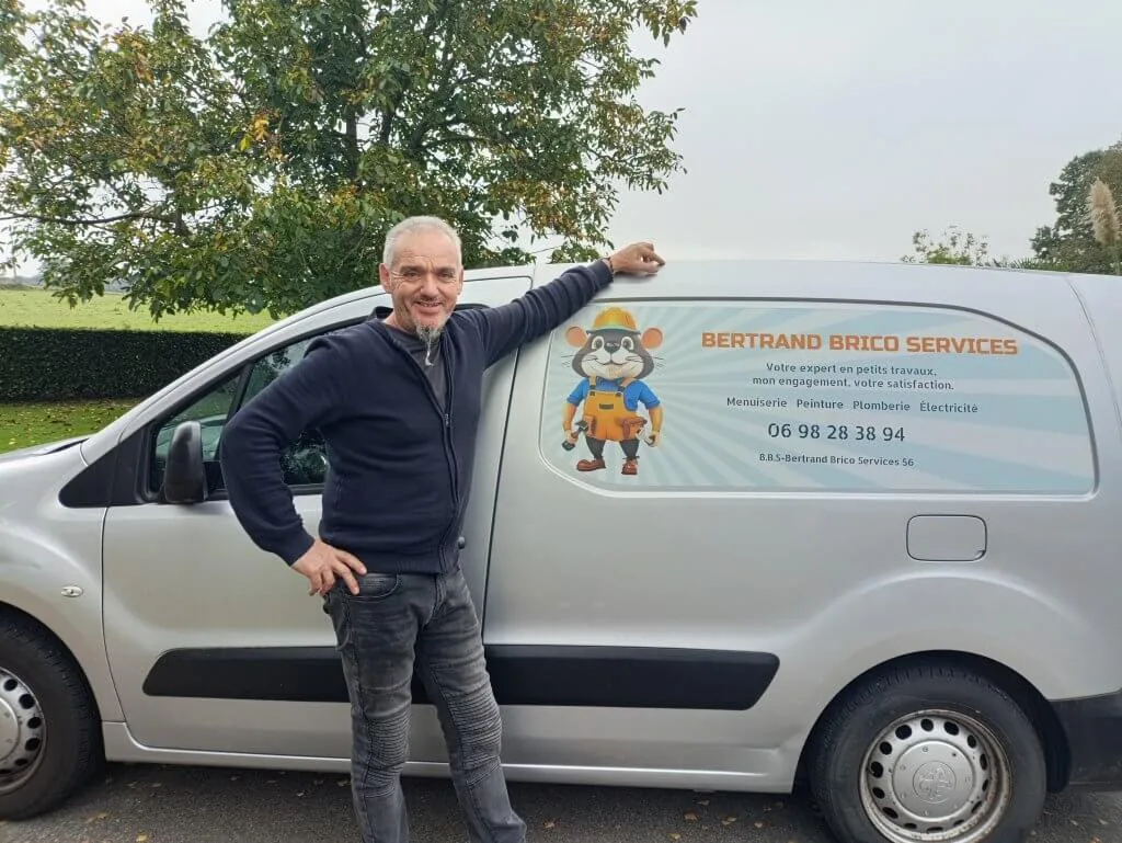 Bertrand Sauvage devant son véhicule de service marqué avec son logo et les coordonnées de son entreprise